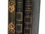 trois livres sont empilés sur une surface blanche