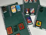 trois chemises vertes ornées de différents types d'insignes, posées sur une table