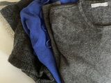 three pairs of gray and blue shirts stacked on top of each other