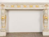 an image of a white marble fireplace with gold decorations