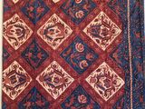 un tapis rouge et bleu orné d'un motif de fleurs et de feuilles
