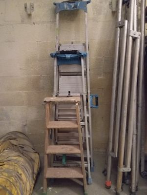 une échelle appuyée contre un mur, à côté d'un lit