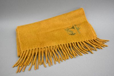 une photo d'une écharpe jaune à franges posée sur une table