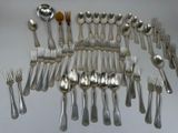 many forks and spoons laid out on the table