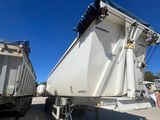 deux camions-bennes garés l'un à côté de l'autre sur un parking