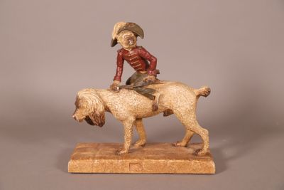 statue représentant un garçon à cheval accompagné d'un chien, posée sur un socle