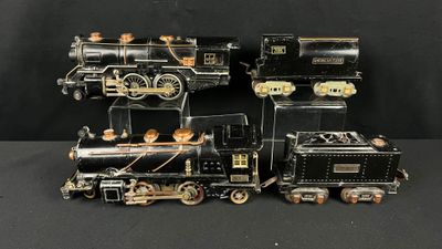 deux locomotives noires et dorées placées côte à côte sur une surface noire
