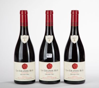 three bottles of red wine sitting on top of a table