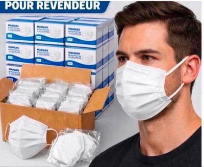a man wearing a face mask next to a box of face masks
