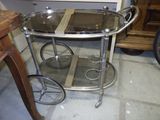 une table en verre munie de deux roulettes, dans une pièce