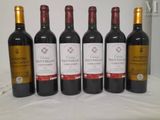 six bottles of red wine are lined up on a table