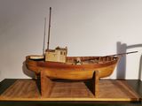 a wooden model of a boat on display on a table