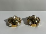 une paire de boucles d'oreilles en or et perles posées sur un fond blanc