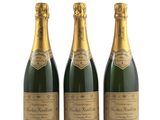 trois bouteilles de champagne posées les unes à côté des autres sur une surface blanche