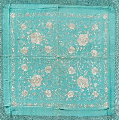 une écharpe à motifs floraux bleus et blancs, bordée d'or