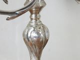 a silver candle that is on a stand on a table