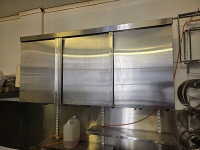 un grand réfrigérateur en acier inoxydable dans une cuisine professionnelle