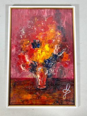 un tableau accroché au mur d'une pièce où se trouve un vase de fleurs