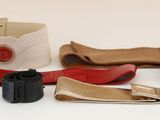une ceinture, une ceinture, un appareil photo et d'autres objets posés sur une surface blanche