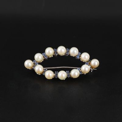 une barrette ornée d'une perle blanche et d'un saphir