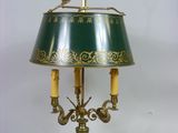 une lampe verte surmontée d'un abat-jour vert et doré