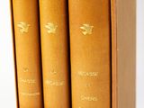 trois livres sont posés dans une boîte sur une surface blanche