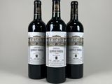trois bouteilles de vin posées sur une table blanche