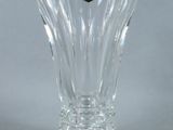 a clear glass vase with a gold emblem on it