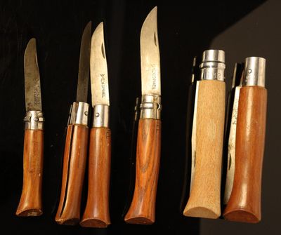 several knives are lined up in a row on a black surface