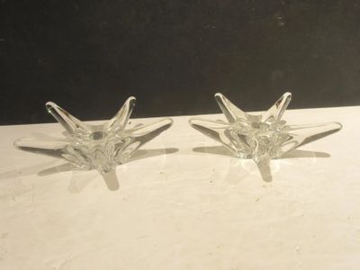 une paire de décorations en verre transparent en forme d'étoile posées sur une table blanche