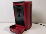 a red coffee maker sitting on a white table