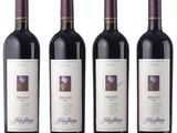 three bottles of red wine are lined up on a white surface