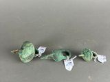 a group of three green beads sitting on top of a table