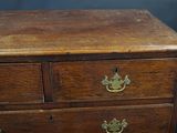 a wooden chest of drawers with brass handles on it