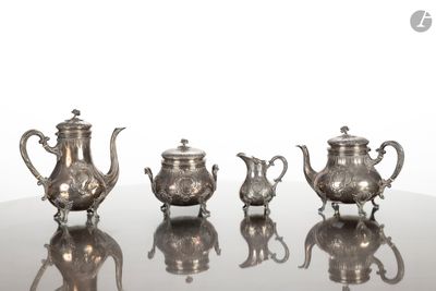cinq théières en argent posées sur une table en verre