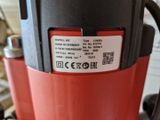 a close up of a red and black drill on a table