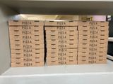 several boxes of pizza are stacked on a shelf in a store