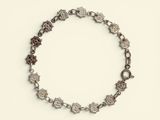 an image of a silver bracelet with flowers on a white background