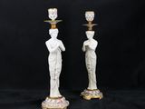 a pair of white statues with gold and pink flowers on them