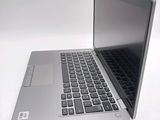 a silver laptop with a black keyboard on a white surface