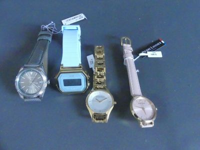 trois montres et un stylo posés les uns à côté des autres sur une table