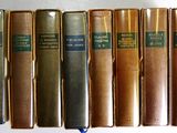 plusieurs vieux livres sont alignés sur une étagère