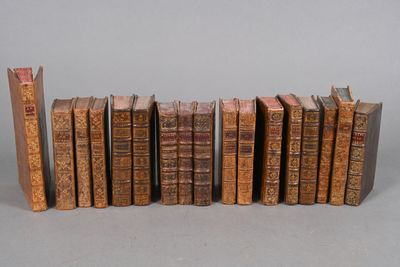 several old books lined up in a row on a gray surface