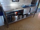 pots and pans sitting on a metal shelf in a kitchen
