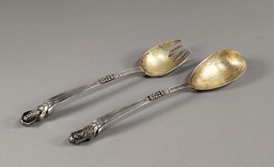 deux cuillères et une fourchette en argent sur une surface grise