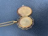 an old gold locke with a chain around it on a blue surface