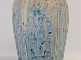 un vase bleu sur lequel est représentée une femme