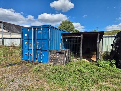 un conteneur bleu posé au milieu d'un champ
