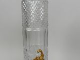 a glass bottle with a gold handle on a table