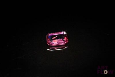 des tourmalines roses dans une pièce sombre, sur fond noir